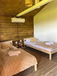 due letti in una stanza con pareti in legno di Casuta 5 a Ciocănari