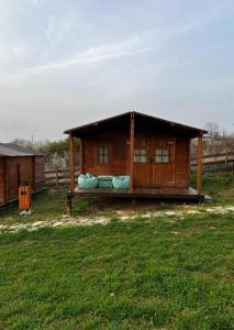 una piccola casa in legno con portico in un campo di Casuta 5 a Ciocănari