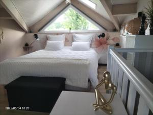 een slaapkamer met een bed in een kamer met een raam bij Au bord du vieux Moulin - près de Bordeaux in Mérignac +18 foto's