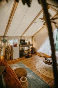 a room with a tent with a wooden floor at Kaluna Glamp Jungle in Swaderki