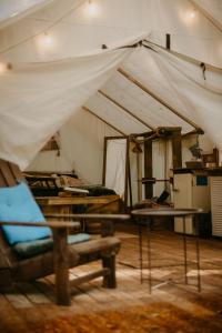 a tent with a chair and a table in a room at Kaluna Glamp Jungle in Swaderki +44 photos
