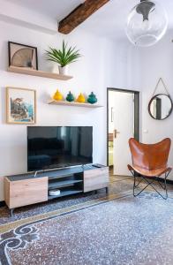 sala de estar con TV grande y silla en Designer apartment in the center of Genoa, en Génova