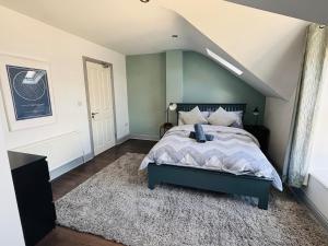 a bedroom with a bed with a blue headboard at Twenty 7 - Modern & Spacious Townhouse in Killaloe