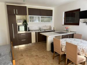 a kitchen with a table and a sink and a counter at Apartman Roguljić in Split