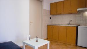 a kitchen with a white table and a white table at Βastasio Apartments Pefkochori in Pefkohori +139 photos
