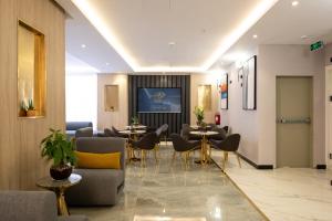 a lobby with tables and chairs in a building at فندق زوايا الماسية الدائري in Al Madinah