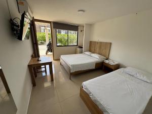 Postel nebo postele na pokoji v ubytování ApartaHotel Los Naranjos
