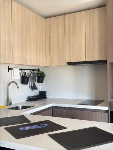 a kitchen with wooden cabinets and a sink at ELDEPTO Padre Mariano Apart Hotel in Santiago