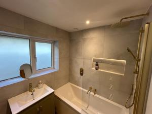 a bathroom with a tub and a sink at Yew Tree Cottage - walks from the door in Colwall +40 photos