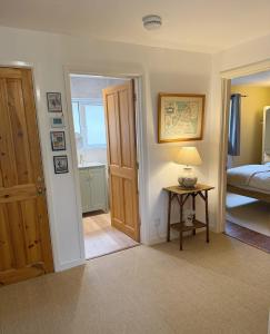 a bedroom with a door and a table with a lamp at Yew Tree Cottage - walks from the door in Colwall