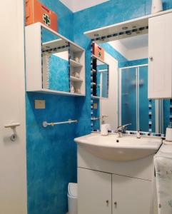 a bathroom with a sink and a blue wall at La Finestra Sul Mare in Stintino