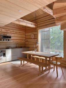 una sala da pranzo con un tavolo e una grande finestra di Handcrafted Log Chalet Villa Aarreaitta a Pudasjärvi