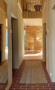 un corridoio di una casa con pareti in legno e scala di Handcrafted Log Chalet Villa Aarreaitta a Pudasjärvi
