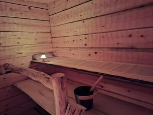 una sauna vuota con un cestino dentro di Handcrafted Log Chalet Villa Aarreaitta a Pudasjärvi