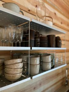 una mensola da cucina con piatti, ciotole e bicchieri di Handcrafted Log Chalet Villa Aarreaitta a Pudasjärvi Altre 28 foto