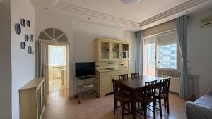 a living room with a dining room table and a television at Adriatico 98 in Fano