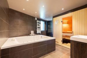 een grote badkamer met een bad en een wastafel bij Chalet grand confort in Pailhac +11 foto's