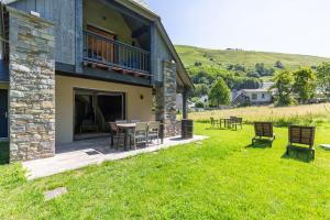 een huis met een tafel en stoelen in de tuin bij Chalet grand confort in Pailhac
