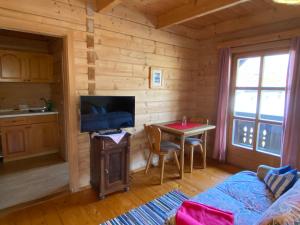 a living room with a table and a television in a cabin at Berggasthof Ferienhaus Gut Lichtenau in Hauzenberg
