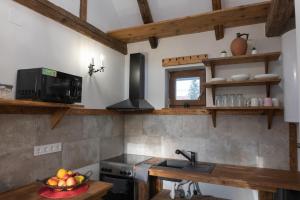 a kitchen with a sink and a counter with a bowl of fruit at Pamacs Vendégház in Balatonendréd