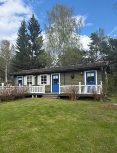 a house with a porch and a yard at Guest House Gäststuga Bullandö in the archipelago in Värmdö