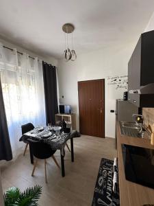 a living room with a table and a kitchen at LORY ROOM vacation home in Quartu SantʼElena +8 photos