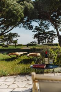 a table with a bottle of wine and a glass at Villa Kenavo - Maison familiale avec vue mer in Île dʼAix