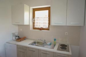 eine Küche mit Spüle und Fenster in der Unterkunft Croatian Home Apartments in Zadar