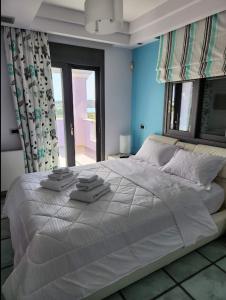 a bedroom with a large bed with towels on it at Villa Dalousa Retreat - Porto Heli in Porto Heli +18 photos