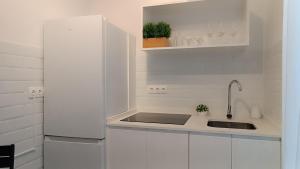 a kitchen with white cabinets and a sink at Sherryflat Terraza San Francisco in Jerez de la Frontera
