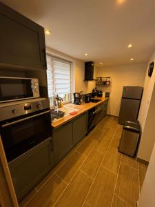 a kitchen with black appliances and a wooden floor at Maison de Campagne in Mecquignies