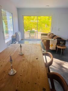 Una sala de estar con una mesa de madera y un sofá. en modern appartement with private garden & shared pool, en Seignosse