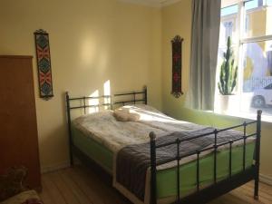 a bedroom with a bed in a room with a window at Solkot Cottage Homestay in Reykjavík