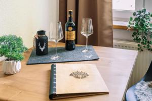 a bottle of wine and two wine glasses on a table at Schwarzwald-Flair mit Naturblick & Balkon in Baiersbronn +9 photos
