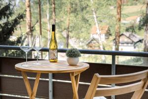 a table with a bottle of wine and two glasses at Schwarzwald-Flair mit Naturblick & Balkon in Baiersbronn