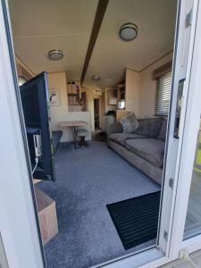 a living room with a couch and a tv at Thornwick bay Yellowhammer 28 in Flamborough