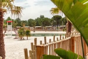 a fence in front of a swimming pool at Mobil home premium plage et piscine domaine la yole proche valras plage in Vendres +10 photos