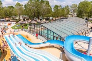 a water slide in a water park with people on it at Mobil home premium plage et piscine domaine la yole proche valras plage in Vendres