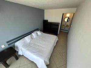 a bedroom with a white bed and a mirror at 106 THE BEST SUNSeT in Coyuca de Benítez