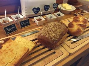 a cutting board with bread and other pastries on it at La Demeure des Elfes in Albinen +12 photos