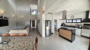 a kitchen and living room with a table and a counter at 50m praia Cond pé na areia Alto padrao 4 suites Segur 24h Costa do sol Guaratuba Bertioga prox Riviera in Bertioga