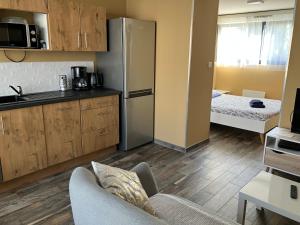 a kitchen with a couch and a refrigerator in a room at Le Petit Fabre in La Roche-sur-Yon