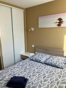 a bedroom with a bed with a blue pillow on it at Le Petit Fabre in La Roche-sur-Yon