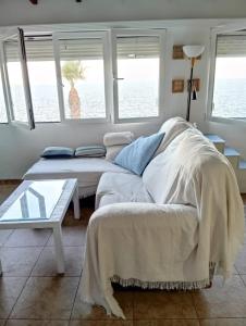 a bedroom with a bed and a table and windows at Primera línea de playa en Villaricos in Villaricos
