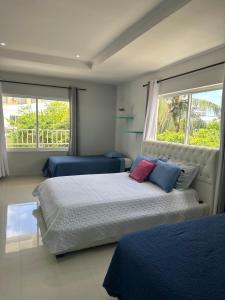 Un dormitorio con dos camas y dos ventanas. en CASA VERANO, en San Andrés