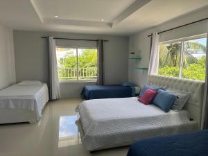 1 dormitorio con 2 camas, sofá y ventana en CASA VERANO, en San Andrés