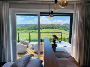 本图贡萨尔维斯Vista Vigneti Albergo & Vino - Vale dos Vinhedos的带桌子和大窗户的客厅