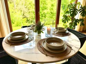 a white table with plates and glasses on it at HIDEAWAYandSPA Villa St Nikolaus in Großrosseln