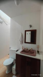 a bathroom with a toilet and a sink and a mirror at Casa Barbosa Paraty in Paraty +34 photos
