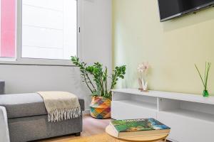 a living room with a couch and a tv at Green Living-Funchal in Funchal